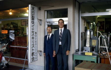 Elders Okano and Goodwin stand in front of the door to the commercial building where the Fukuchiyama branch met.  Next door was a bathroom plumbing fixtures store.  Elder Okano was Branch President in late 1980, Elder Goodwin in early 1981
Brad  Goodwin
30 May 2006